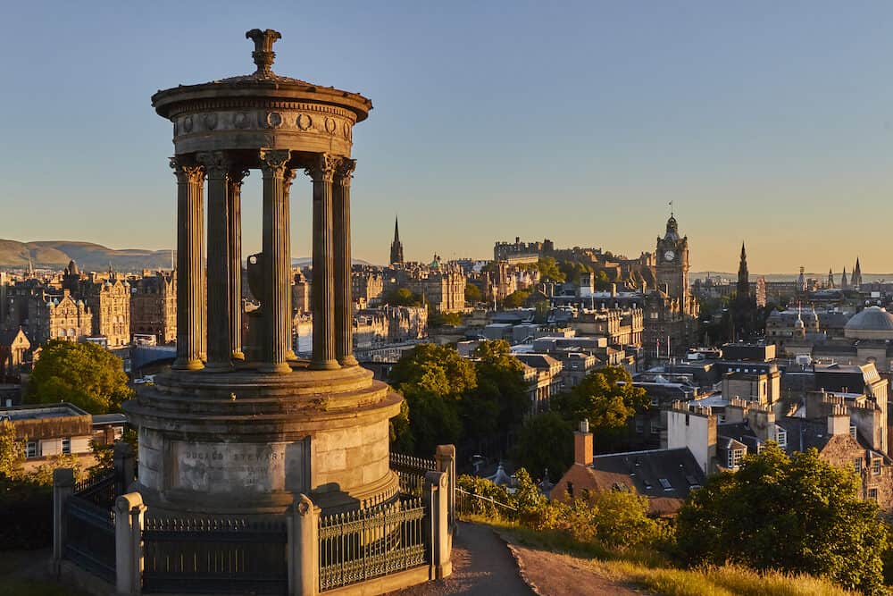 Edinburgh sunset view with Dugald Steward Monument and Edinburgh Castle in the background, Scotland, United Kingdom.