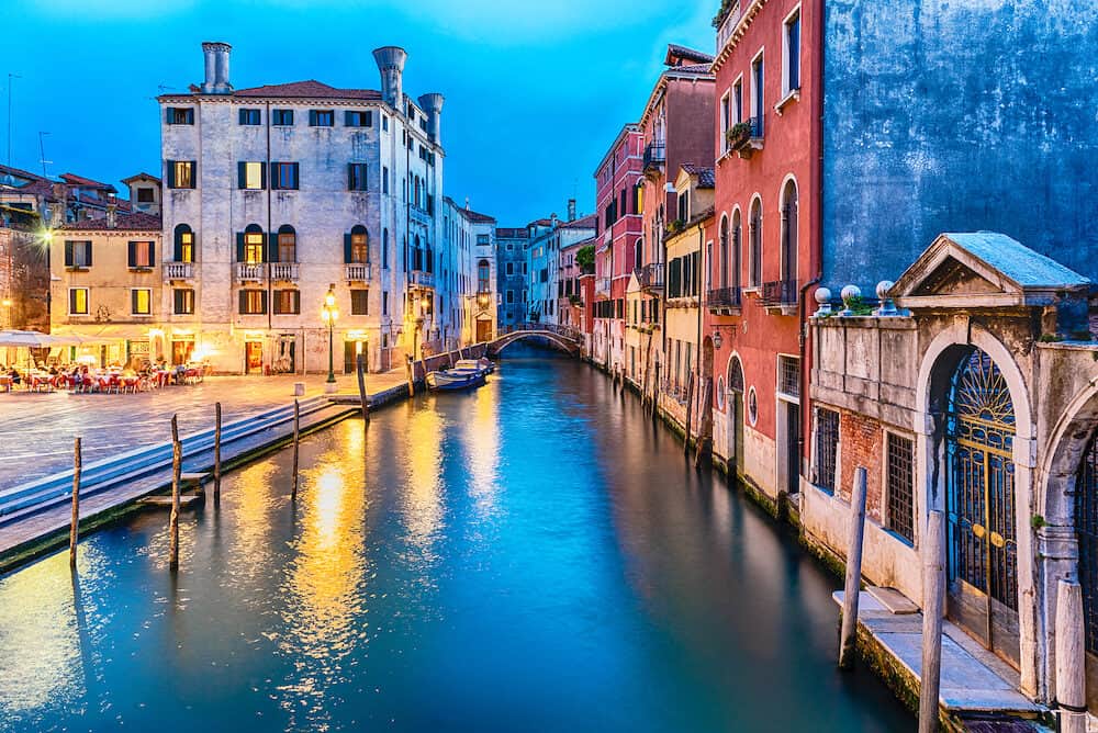 View over a picturesque canal with beautiful reflections in Castello district of Venice, Italy