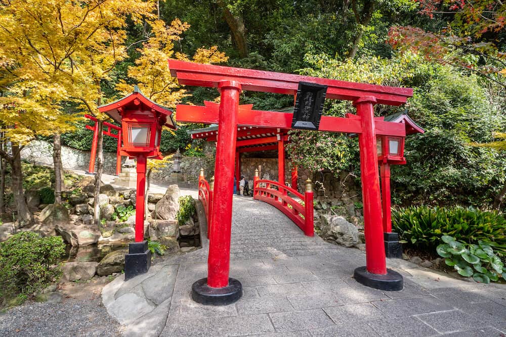 Beppu, Oita, Japan, Japanese red wooden torii near UMI JIGOKU (Sea Hell) pond in autumn, which is one of the famous natural hot springs viewpoint, representing the various hells and is national designated scenic spot