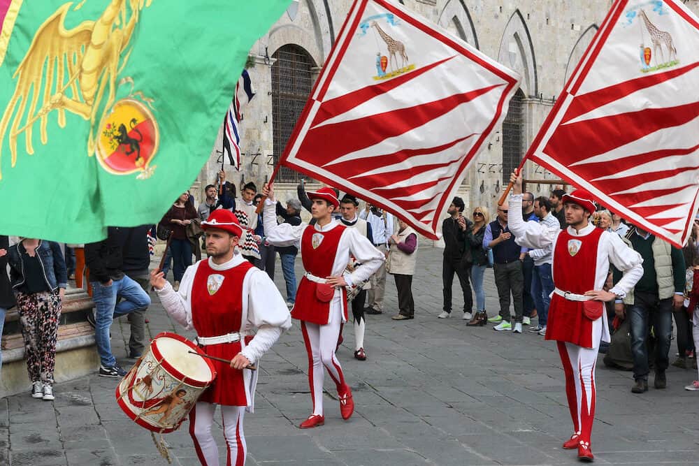 SIENA ITALY - Contrada Giraffe parade marches in Siena Italy. There are famous 17 contrade (districts) representing various traditional professions or groups of Siena history.