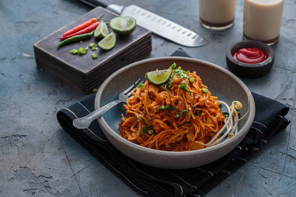 Indian mee goreng or mee goreng mamak, Indonesian and Malaysian cuisine, spicy fried noodles in a plate, copy space