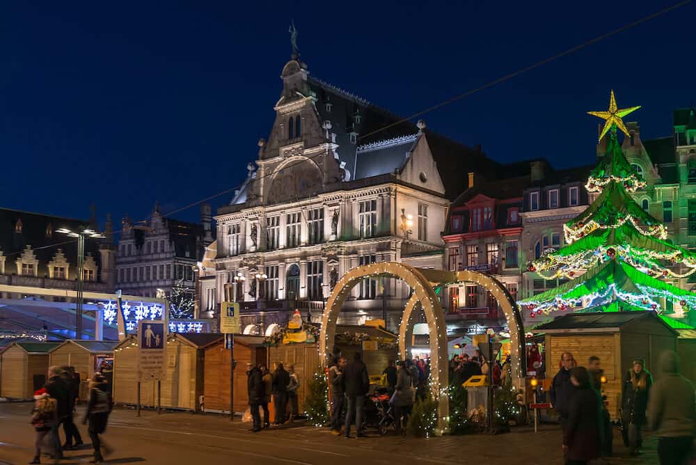Ghent, Belgium - Gent city winter festival in Flanders. Christmas fair with Xmas tree and festive decorations surrounded by historical buildings on the Ghent Old town square.