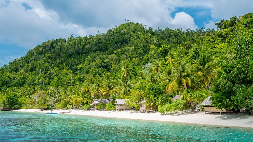 Bamboo Huts on the Beach, Coral Reef of an Homestay Gam Island, West Papuan, Raja Ampat, Indonesia