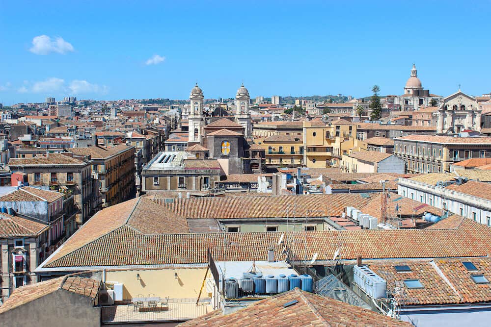 Beautiful cityscape of Sicilian city Catania, Italy taken from a view point above the city center. Catania has many historical sites and is a popular tourist attraction. Blue sky, sunny day.