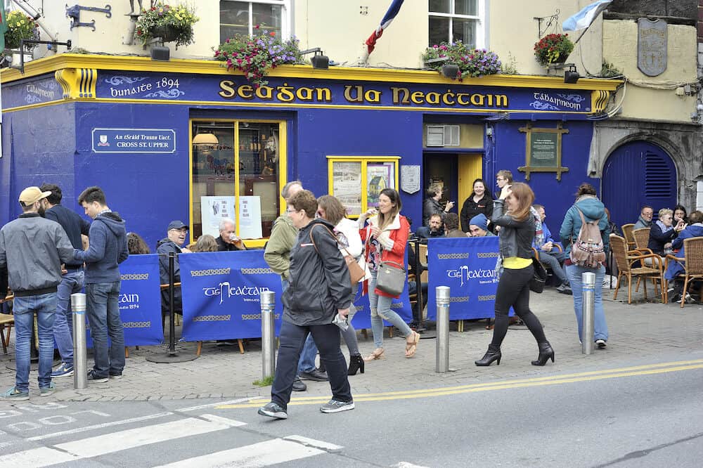 Latin Quarter Galway Ireland. Tigh Neachtain irish traditional bar since 1894 Main entrance people drinking smoking in the outside of the bar.