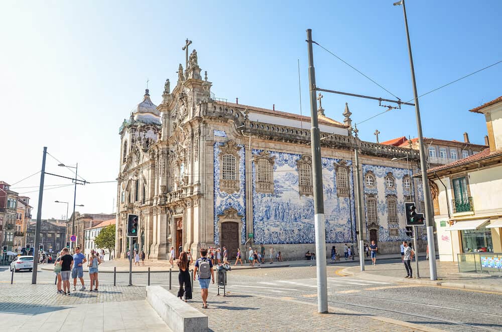 Porto, Portugal - People on the street by famous Igreja do Carmo and adjacent Igreja dos Carmelitas. Traditional Portuguese tiles azulejos on church facade. Street with people