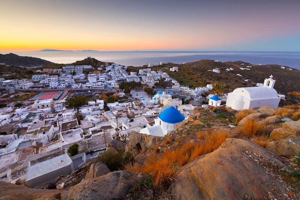 View of Chora on Ios island early in the morning. Santorini island can be seen on the horizon.