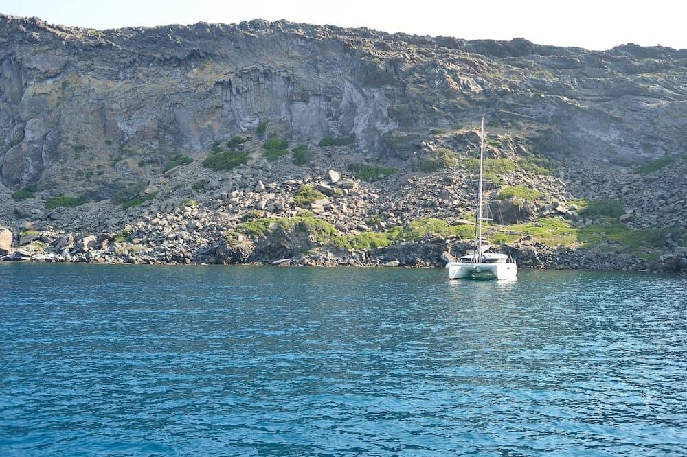 SANTORINI, GREECE - people on yacht near Santorini sea coast. Santorini, is an island in the southern Aegean Sea, about 200 km southeast of Greece's mainland.