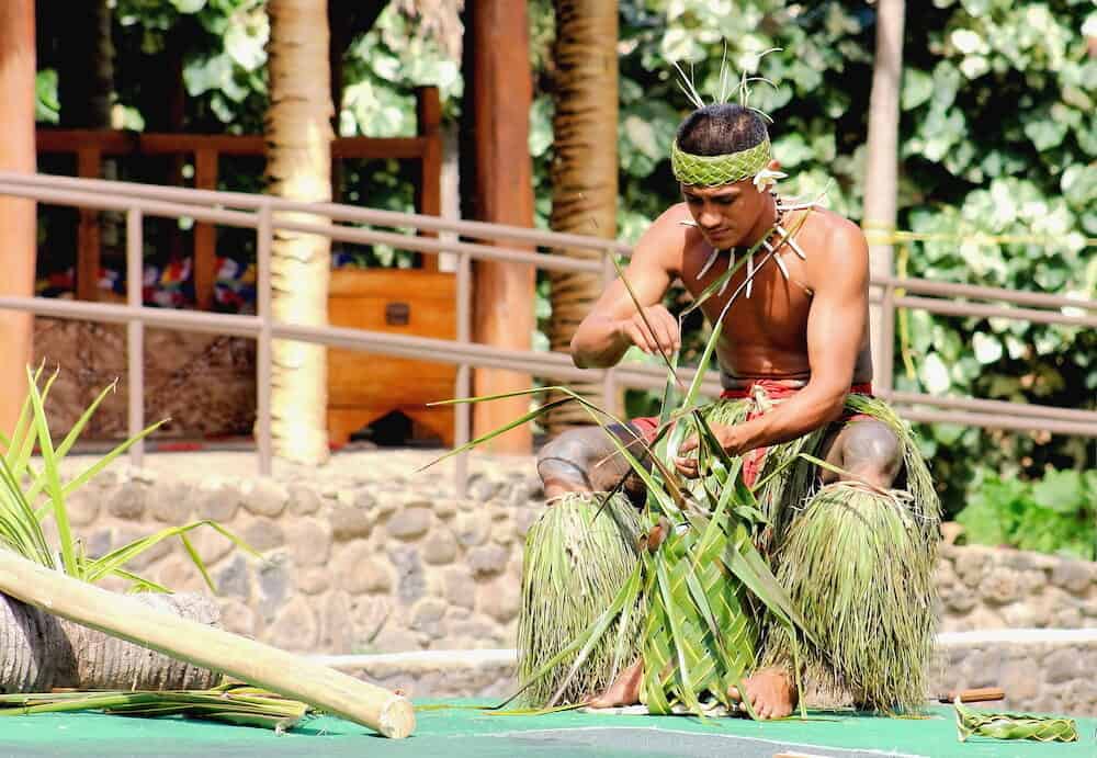 A young Samoan man demonstrating the art of weaving in the Village of Samoa at the Polynesian Cultural Center.