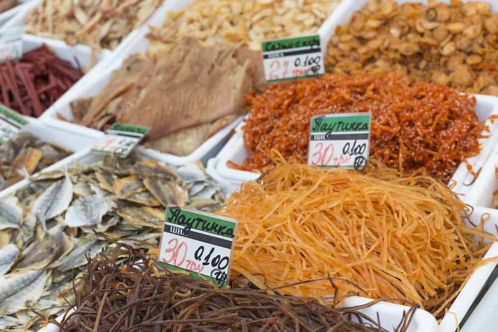 Dried salted fish at a farmers market. The price tags on each product with the title.