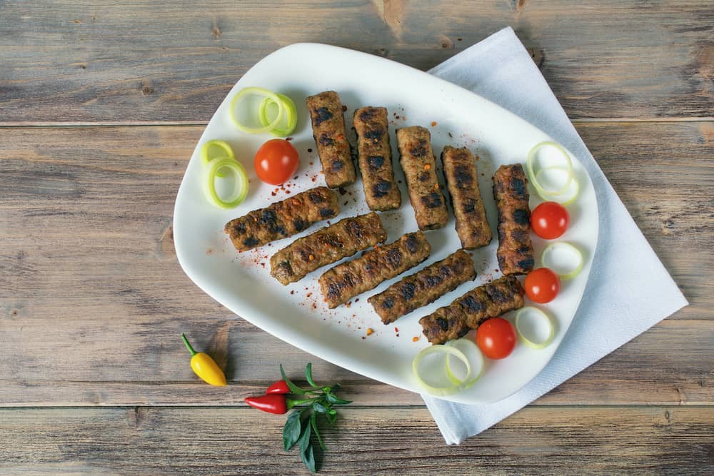 Balkan cuisine. Cevapi - grilled dish of minced meat. Rustic background