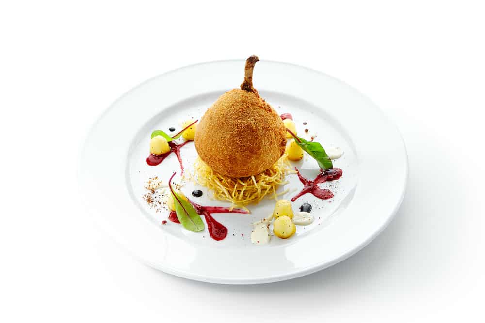 Fried chicken Kiev or cutlet Kiev-style made of chicken fillet pounded and rolled around cold butter, coated with bread crumbs. Beautiful creative food design on white plate with spices and sauce