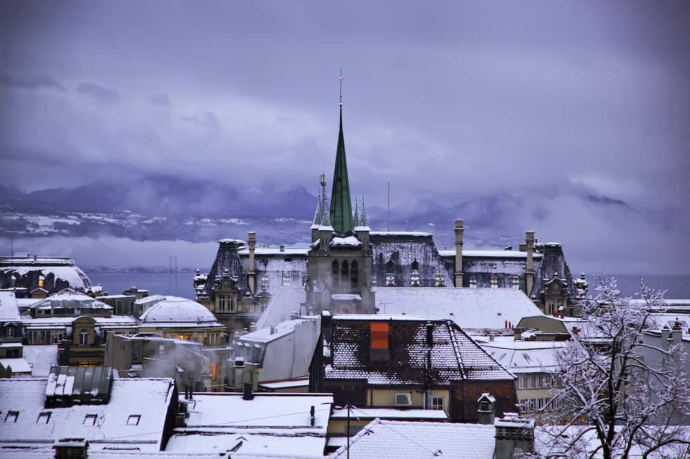 Winter evening in Lausanne. Skyline of Lausanne, Switzerland as seen from the Cathedral hill at sunset zoomed-in on the tower of St-Francois Church.