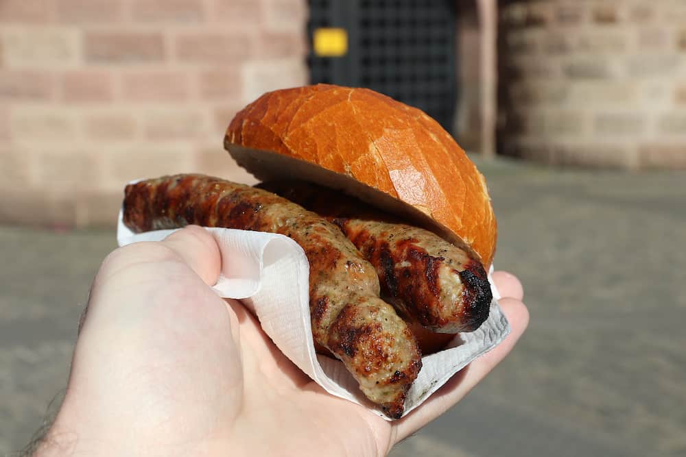 Franconian sausage (bratwurst) in a bread roll - street food in Nuremberg, Germany.