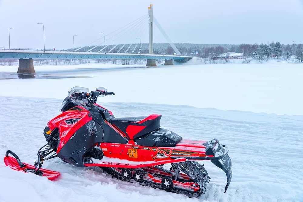 Rovaniemi Finland - Red snowmobile on frozen lake at Candle bridge in winter Rovaniemi Lapland Finland