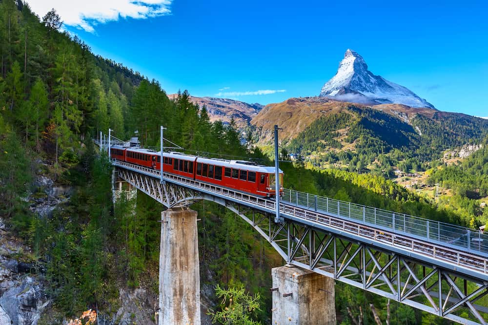 Zermatt, Switzerland. Gornergrat red tourist train on the bridge and Matterhorn peal panorama in Swiss Alps