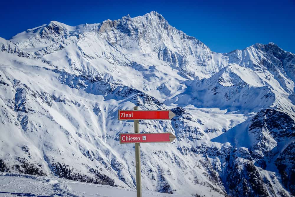 Weisshorn peak, a major peak in swiss alps as seen from Sorbois gondola station, Zinal Grimentz, Switzerland in winter. In the front you see ski slope signs.