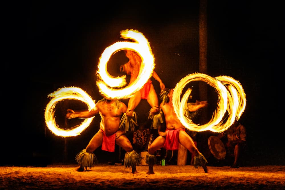 Luau hawaiian fire dancers motion blur tourist attraction in Hawaii or French Polynesia, traditional polynesian dance with men dancer.