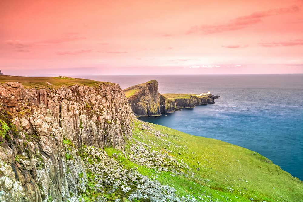 Neist Point cliff with Lighthouse on top, located in the Isle of Skye, Highlands in Scotland, United Kingdom at sunset. Neist Point is a very photographed place and tourist attraction on Isle of Skye.