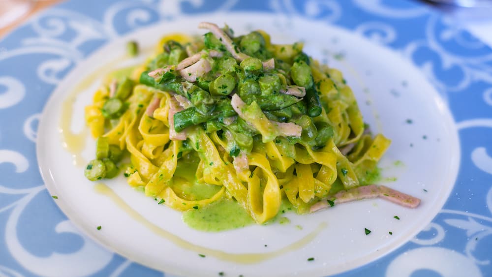 travel to Italy - plate with tagliatelle asparagus and ham in restaurant in Verona city in spring