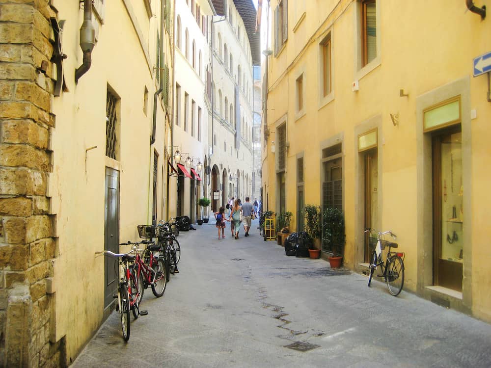 Small local old town street in Tuscany city of Florence, italy, Europe. Architecture colorfull landmark of Florence. Cozy, cute empty cityscape street with parked bikes on bright warm summer day