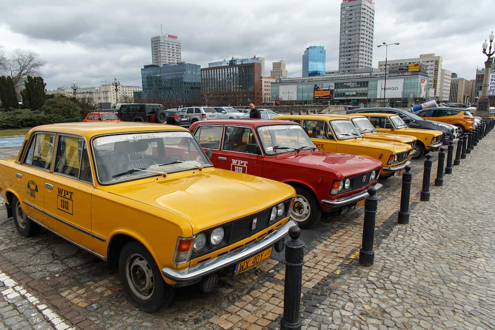 Warsaw, Poland - A row of yellow and red retro taxi, a Polski Fiat 125p on parking near the Palace of Culture and Science, Warsaw, Poland