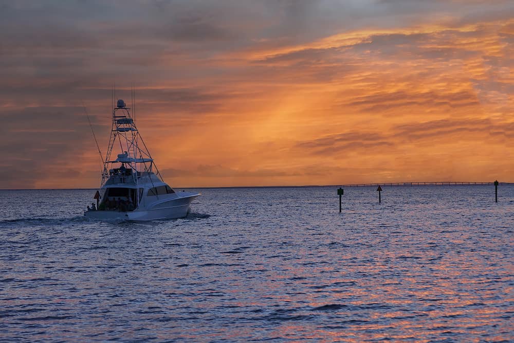 Large fishing troller heading out at sunset on the Gulf of Mexico in Destin, located in the Panhandle of Florida.