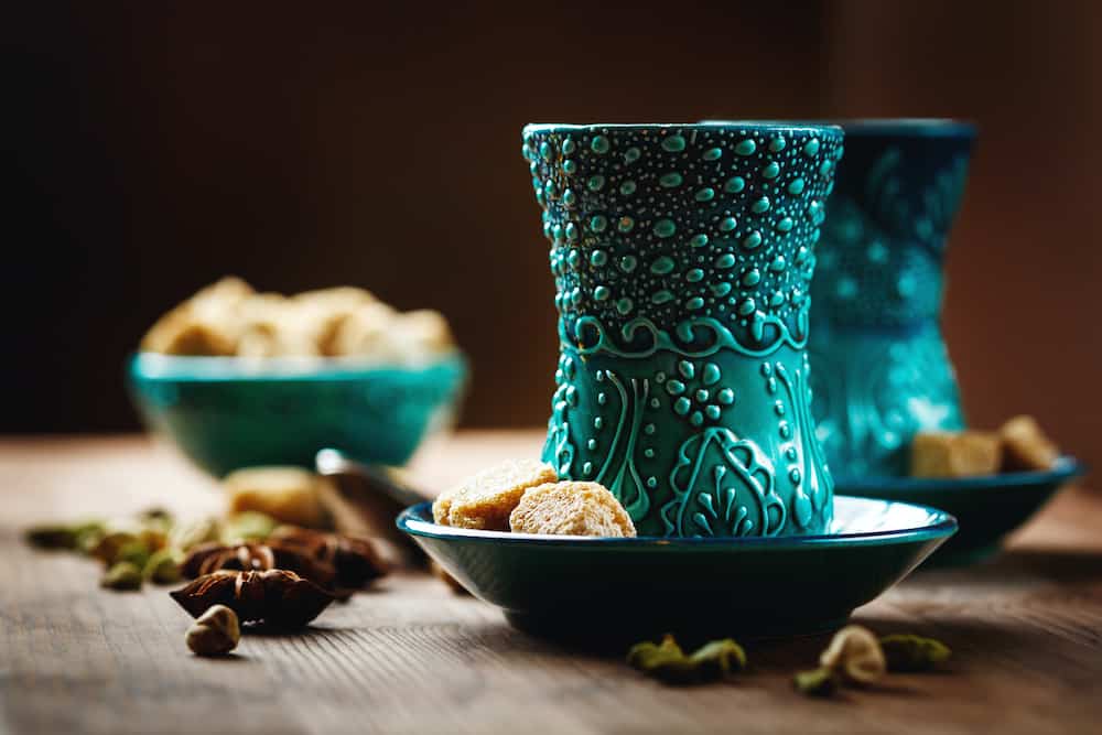 Tea or Hot Wine with Various Spices in Traditional Turkish Glasses on Wooden Background. Selective Focus. Surface View.