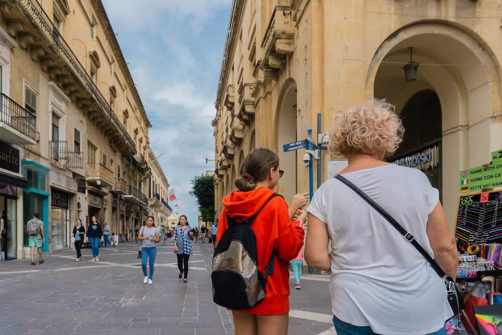 Valletta, Malta - Tourists walking down the street in Valletta, the capital of Malta