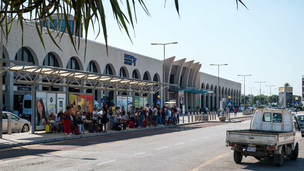 Gudja, Malta - tourists at the bus station in front of the Malta international Airport