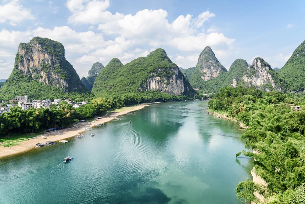 Beautiful view of the Li River (Lijiang River) with azure water among scenic karst mountains at Yangshuo County of Guilin, China. Amazing green hills on blue sky background. Summer sunny landscape.