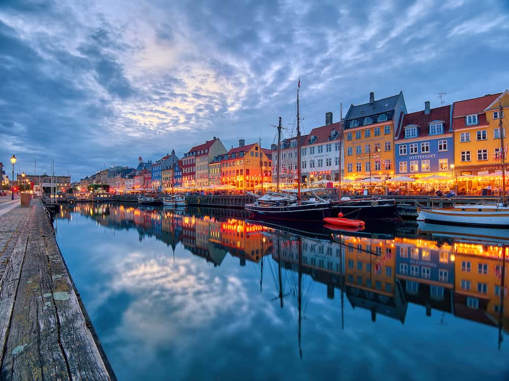 Copenhagen, Denmark - Famous old Nyhavn port in the center of Copenhagen, Denmark during summer night. Copenhagen iconic view