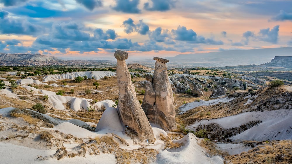 Fairy chimney rock formations of Cappadocia landscape under dramatic clouds.