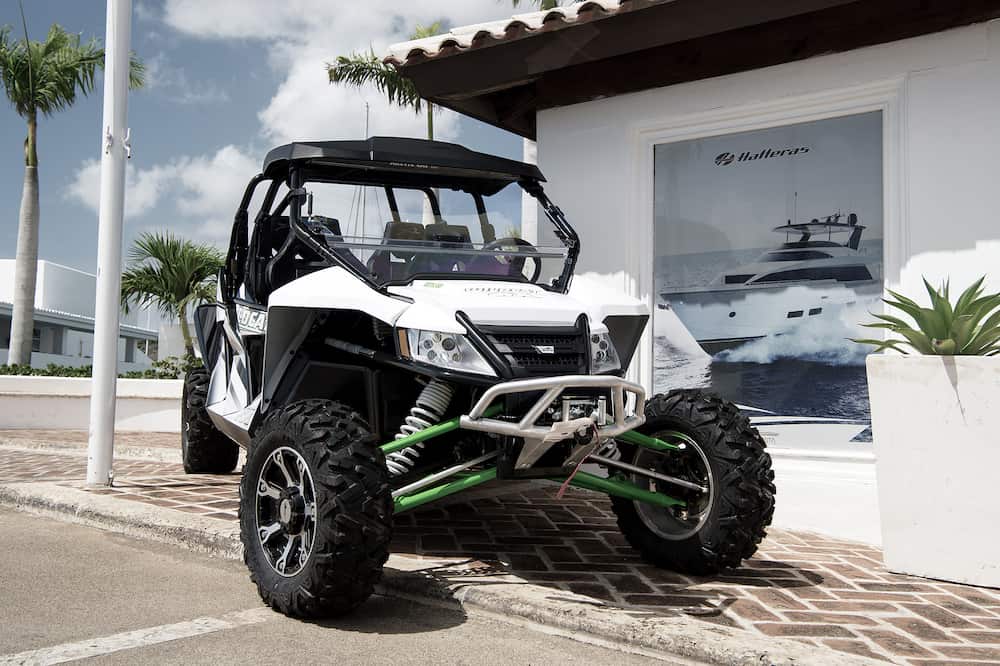 La Romana, Dominican Republic-big cool sport open car of arctic cat brand with wheels and hull white and green color parking sunny day outdoor near building