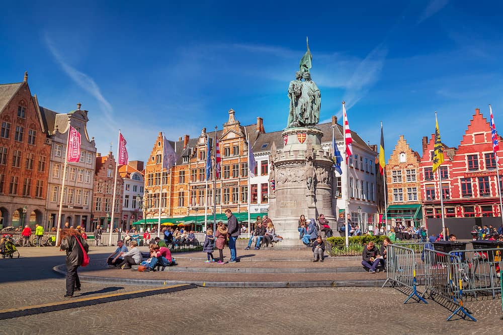Bruges, Belgium - Market place or Grote Markt square with colorful traditional houses, statue of Jan Breydel and Pieter de Coninck, people