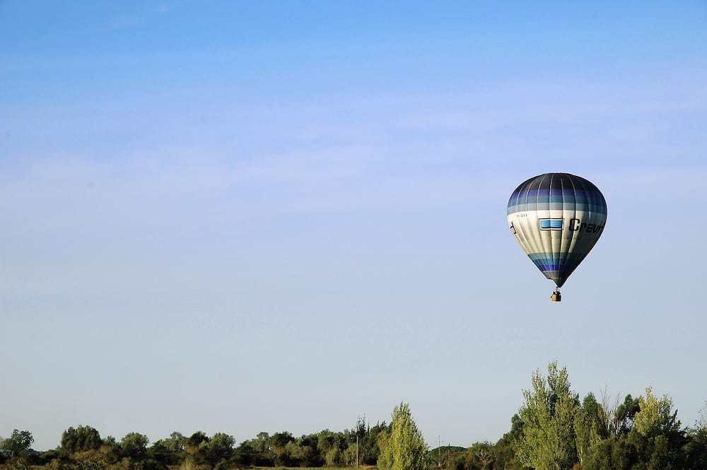 Lagos, Algarve, Portugal - Hot air balloon flying low over trees