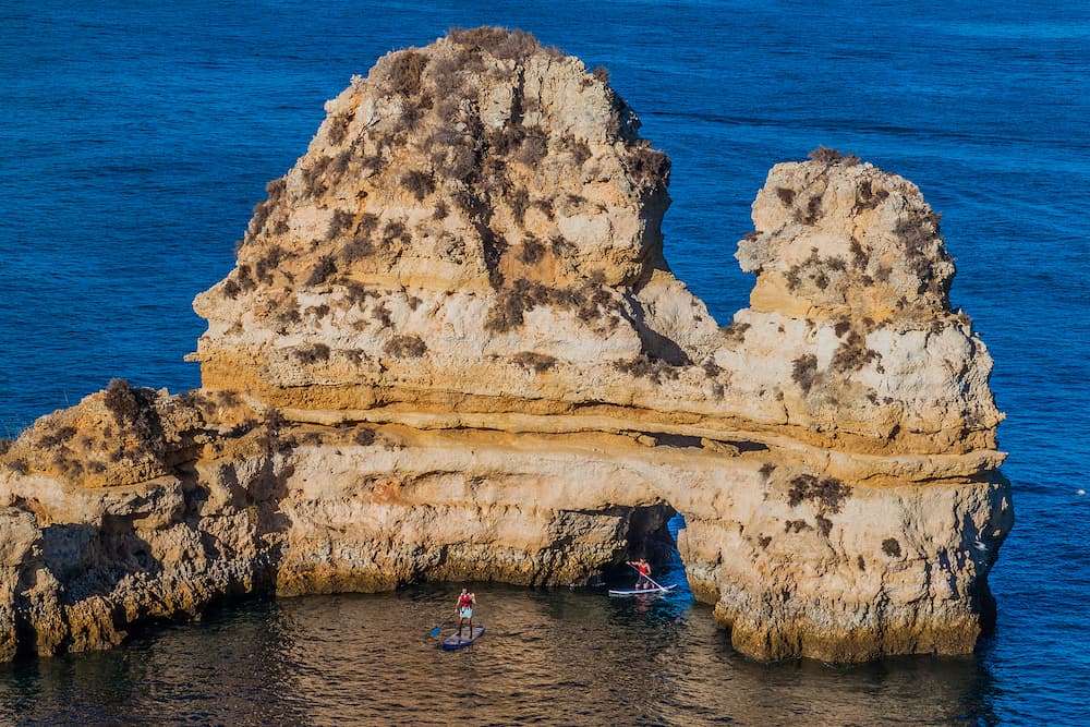 LAGOS, PORTUGAL - Stand-up paddleboarding at the cliffs near Lagos, Portugal.