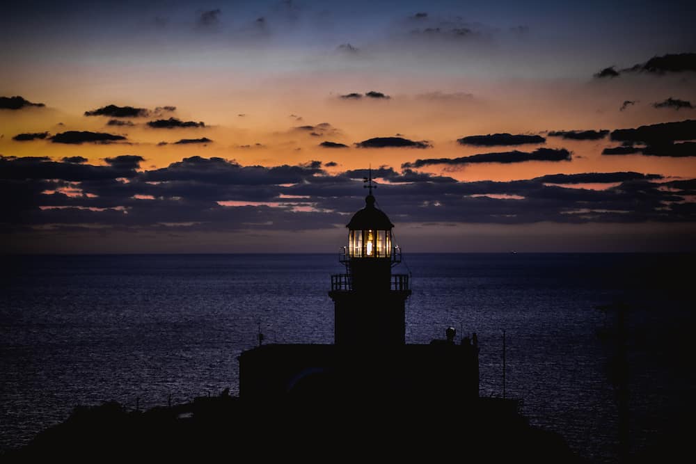 Akrotiri Lighthouse in Sunset facing the Aegian sea, Santorini
