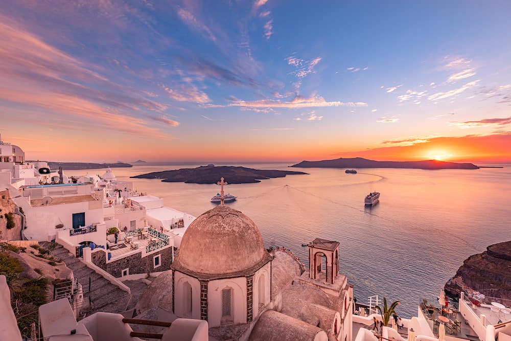 Santorini at night, long exposure photograph after sunset, Mediterranean sea, Greece. Romantic Santorini island during sunset, Greece, Europe. Summer traveling concept. Luxury vacation destination, cruise ship and colorful cloudy sky