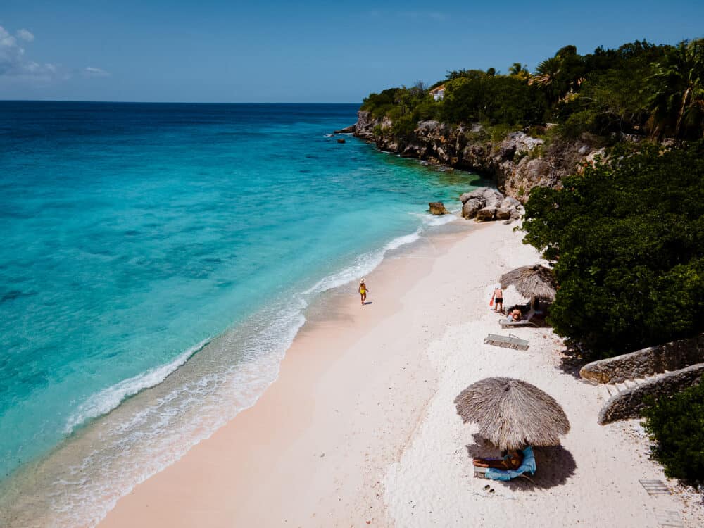 Small Curacao Island famous for day trips and snorkeling tours on white beaches blue clear ocean, Curacao Island in the Caribbean sea. a couple of men and woman on the beach during a vacation holiday