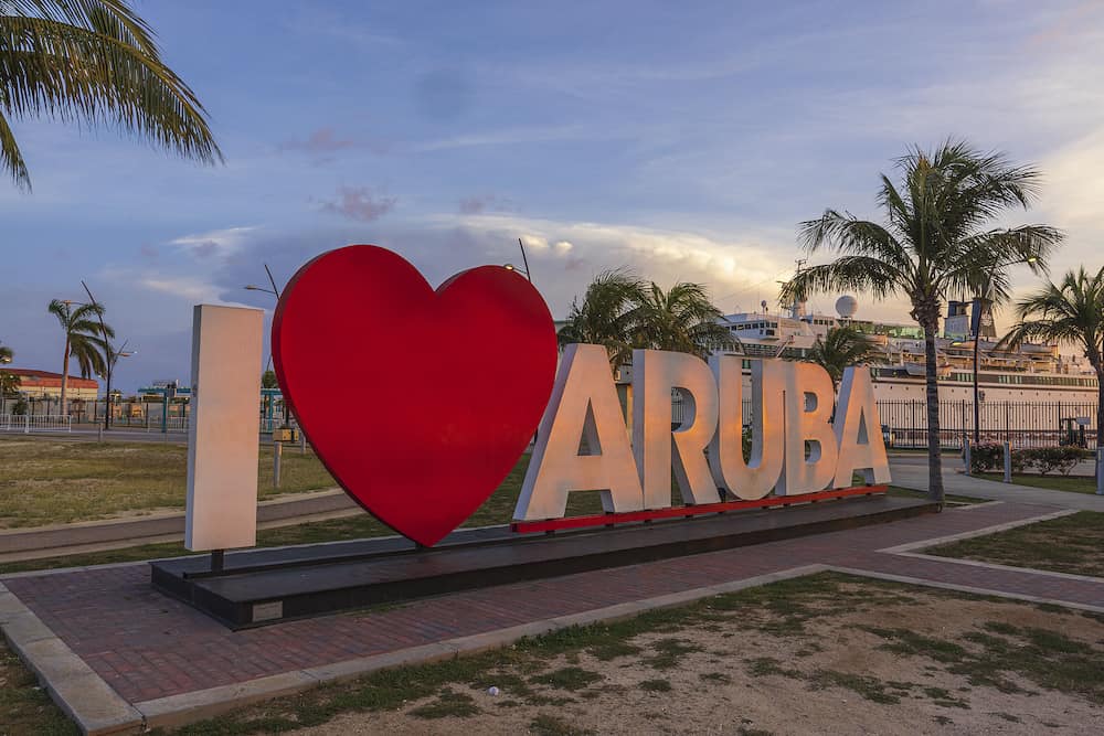 Close up view of large white letters I love Aruba at sunset in center of Oranjestad, capital of Aruba. Big red heart replaces word love. Aruba. Oranjestad