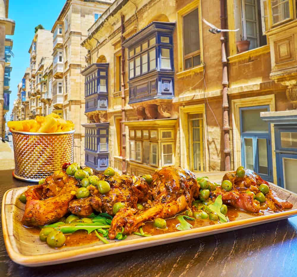 Enjoy the rabbit, stewed in red wine with beans, herbs and spices in the popular restaurant of Strait street, Valletta, Malta.