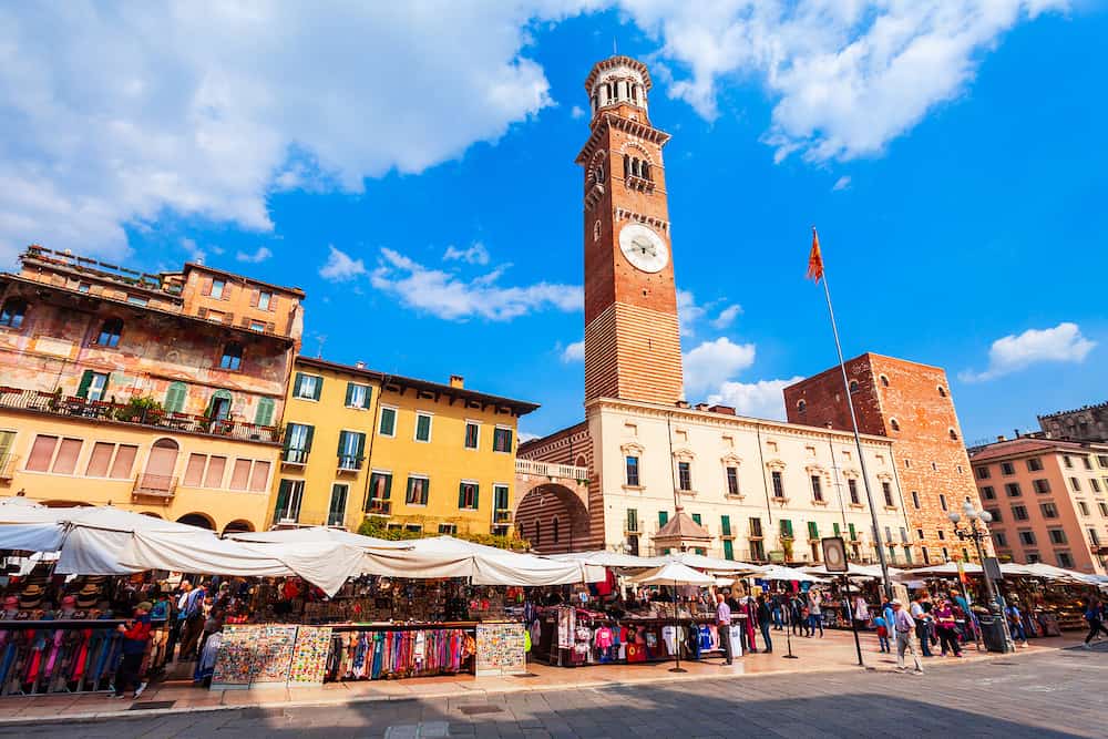 VERONA, ITALY - Torre dei Lamberti tower and souvenir market at Piazza delle Erbe square in Verona, Veneto region in Italy.