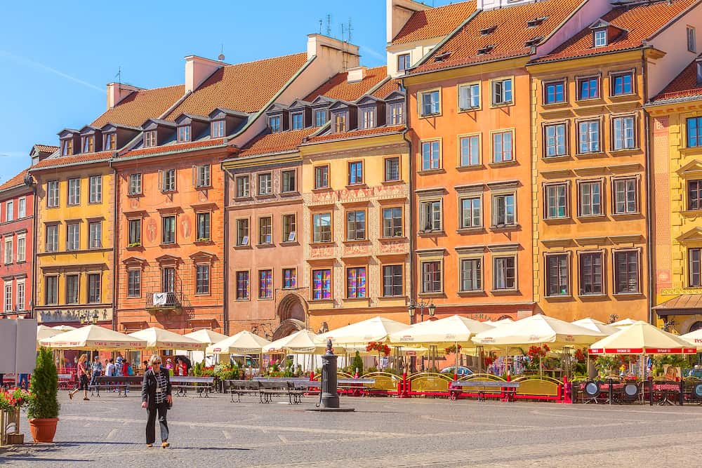 Warsaw, Poland - Cafe with flowers, colorful houses in Market Square in the Old Town of polish capital