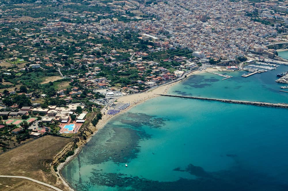 Aerial view of the sandy Magaggiari beach in Cinisi, Palermo, Sicily. The facilities of the Florio Park Hotel can be seen in the bottom left with the port and Terrasini town beyond.