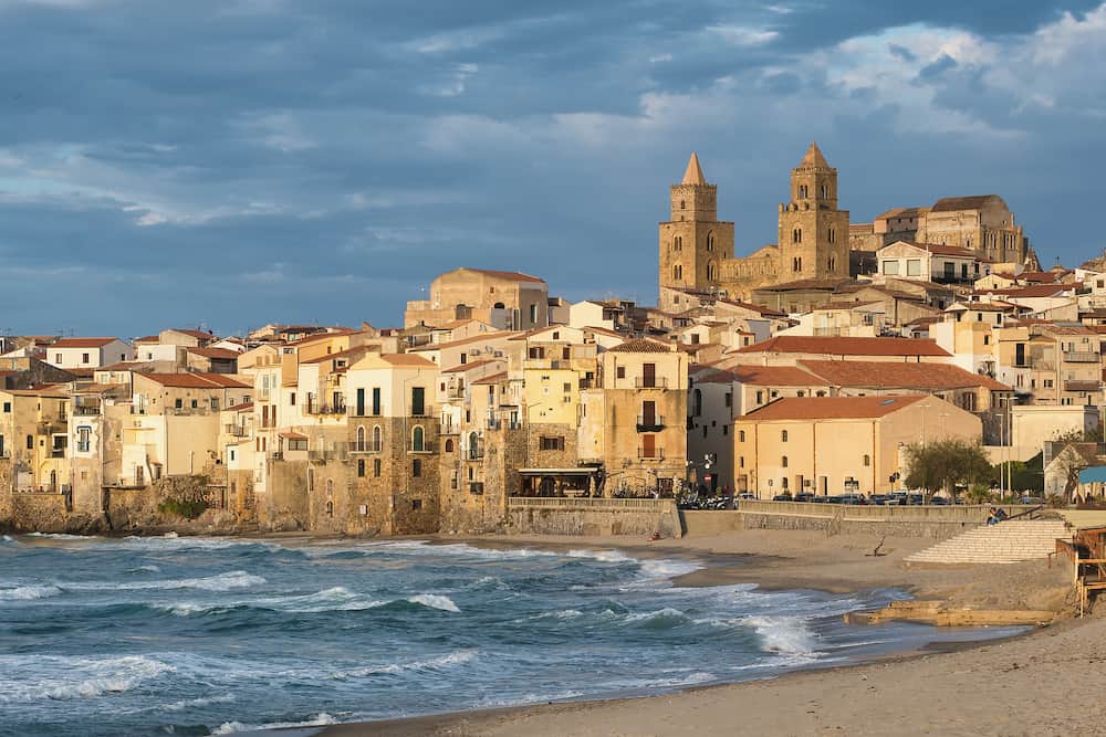 Cefalu cityscape at sunset in province of Palermo, Sicily, Italy. Medieval sicilian town Cefalu. Old town Cefalu and Cathedral Basilica in sunset light
