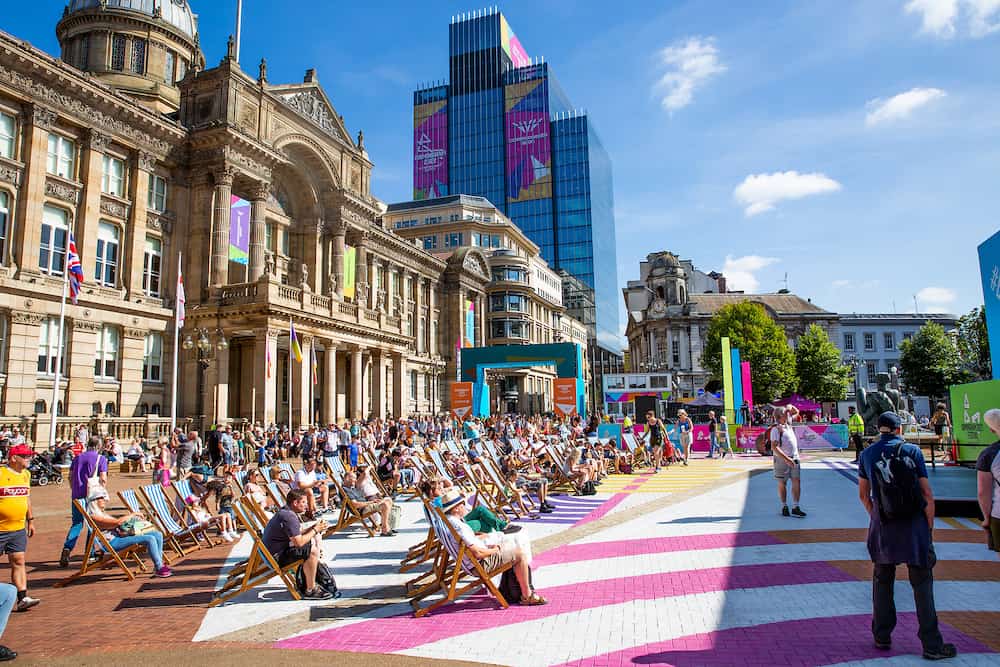 BIRMINGHAM, UK - Crowds of people watching The Commonwealth Games 2022 Festival Site in Victoria Square, Birmingham with the ancient British architecture of The Council House and Town Hall, 2022. A landscape view of The Commonwealth Game