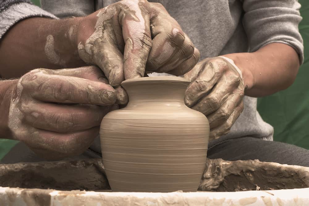 Potter teaches the student the art of clay pottery