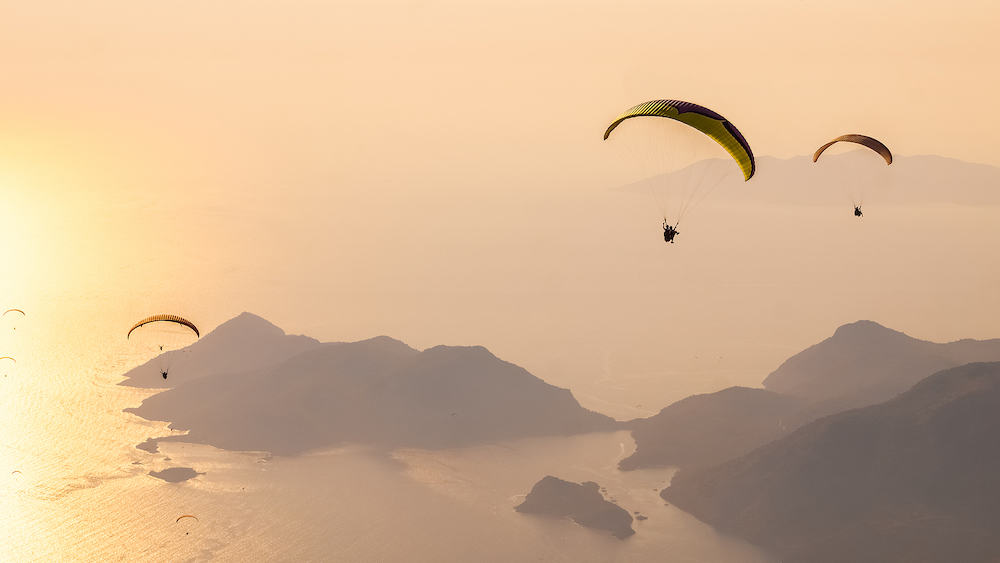 Paragliders flying on Oludeniz beach at sunset in Fethiye, Mugla. Summer and holiday concept.
