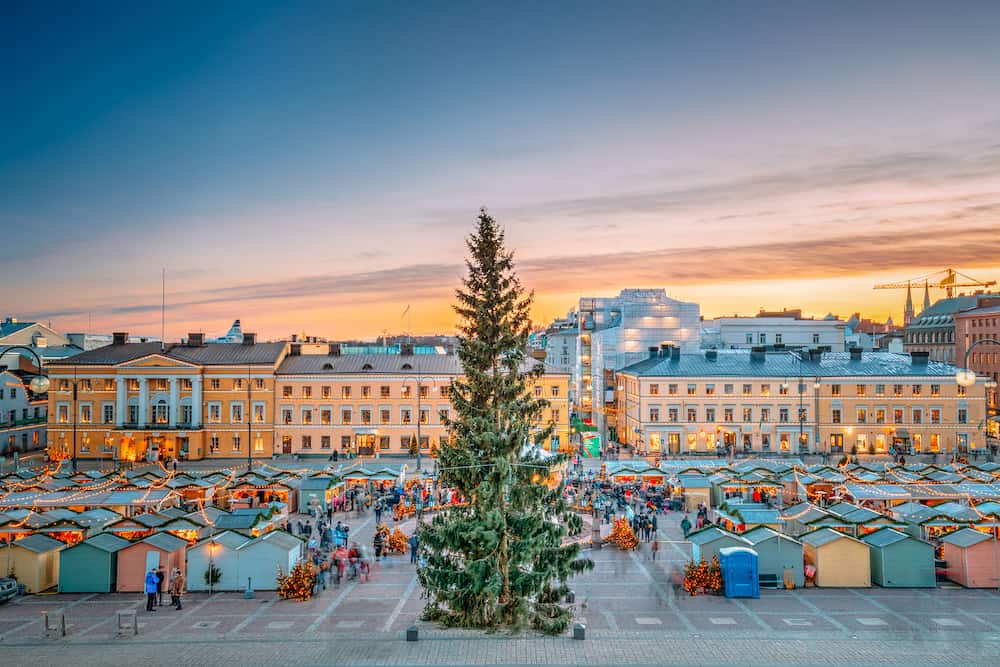 Helsinki, Finland. Christmas Xmas Market With Christmas Tree On Senate Square In Sunset Sunrise Evening Illuminations.